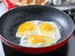 menggoreng telur